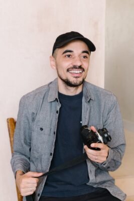Portrait of photographer and tea enthusiast Matthew Ritson holding a handcrafted glass teacup